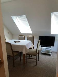 a dining room with a table and chairs and a tv at Ferienwohnung Schlossberg 3 in Wirsberg