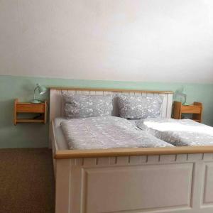 a bedroom with a large white bed with two pillows at Ferienwohnung Schlossberg 3 in Wirsberg