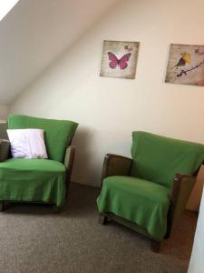 two green chairs sitting next to each other in a room at Ferienwohnung Schlossberg 3 in Wirsberg
