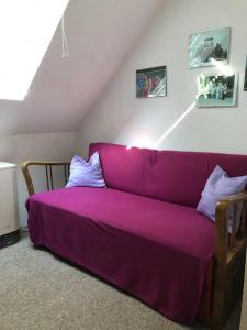 um sofá roxo no canto de um quarto em Ferienwohnung Schlossberg 3 em Wirsberg