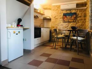 uma cozinha com mesa e cadeiras num quarto em Stone house Saint Michael em Košute
