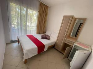 a bedroom with a bed and a mirror and a window at Aparthotel Vila Tufi in Velipojë