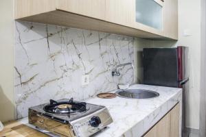 a kitchen with a stove and a sink at RedLiving Apartemen Paradise Mansion - Gunawan in Jakarta