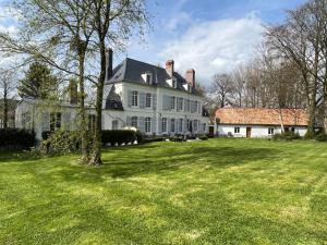 una gran casa blanca con un gran patio en Domaine de la Course, en Doudeauville