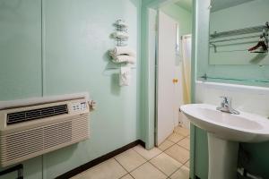 a bathroom with a sink and a air conditioner at Route 66 Inn of Santa Rosa, NM in Santa Rosa +20 photos