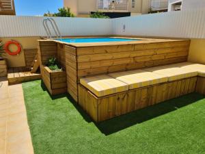 uma piscina com um deque de madeira e relva em Holiday Home Sunny Home by Interhome em Pêra