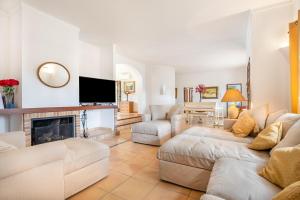 a living room with white furniture and a fireplace at Wonderful 5 Bed Villa With Private in Cacla D'or
