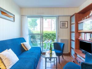 un salon avec un canapé bleu et une table dans l'établissement Apartment Résidence du Port-2 by Interhome, à Cabourg
