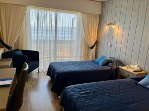 een hotelkamer met 2 bedden en een raam bij Hôtel Restaurant le Panorama in Évian-les-Bains