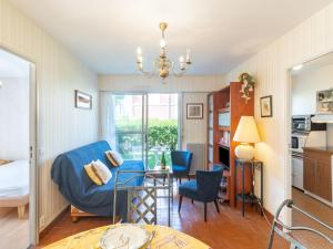 un salon avec une chaise bleue et une table dans l'établissement Apartment Résidence du Port-2 by Interhome, à Cabourg 13 autres photos