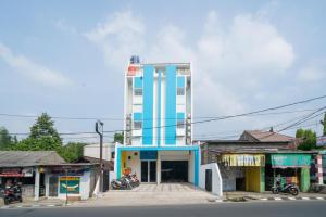 un edificio alto con una torre blu e bianca di RedDoorz at Golden Averis Cibuluh Bogor a Bogor