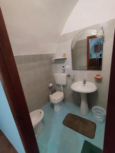La salle de bains est pourvue d'un lavabo, de toilettes et d'un miroir. dans l'établissement La culla sul mare in centro, à Manfredonia