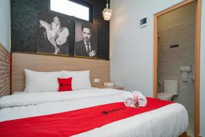 a bedroom with a large bed with a red blanket at RedDoorz at Golden Averis Cibuluh Bogor in Bogor