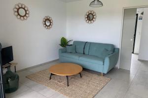 Sala de estar con sofá azul y mesa de centro en appart Libeccio swimming pool bbq, en Calenzana