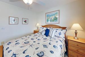 a bedroom with a bed with a blue and white comforter at Cheery Retreat in Newport Beach