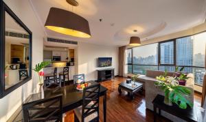 a living room with a dining table and a living room at Bandara Suites Silom, Bangkok - SHA Extra Plus in Bangkok