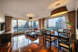 a living room with a couch and a table with chairs at Bandara Suites Silom, Bangkok in Bangkok