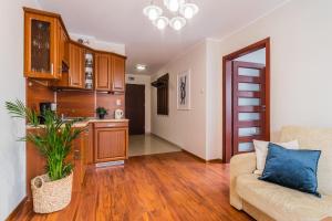 Una sala de estar con un sofá y una cocina. en Flatbook Apartamenty - Port Stegna z Parkingiem, en Stegna 12 fotos más