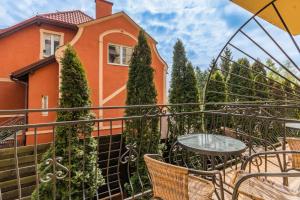 un balcón con mesa y sillas frente a una casa en Flatbook Apartamenty - Port Stegna z Parkingiem, en Stegna