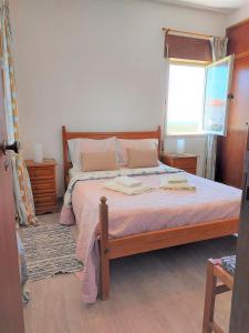 une chambre avec un grand lit avec une fenêtre dans l'établissement Apartamento vista mar e pôr do Sol (1,6km Praia), à Aljezur
