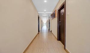 a hallway with white walls and a tile floor at Treebo Surya Yatri Niwas in Belgaum