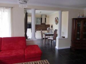 a living room with a red couch and a table at Fewo Ostseetraum_JAeHN in Ostseebad Karlshagen