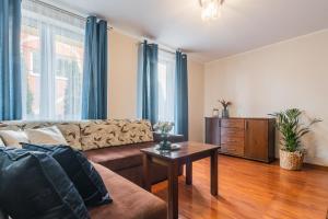 una sala de estar con un sofá y una mesa en Flatbook Apartamenty - Port Stegna z Parkingiem, en Stegna