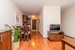 ein Wohnzimmer mit einem Esszimmer und einer Küche in der Unterkunft Flatbook Apartamenty - Port Stegna in Stegna