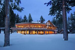 une grande maison dans la neige la nuit dans l'établissement Snowpeak Oasis, à Truckee