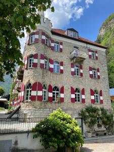 a large brick building with red and white windows at Hotel Sachsenklemme in Fortezza