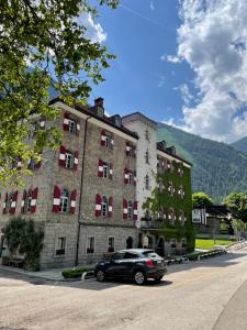 a car parked in front of a large building at Hotel Sachsenklemme in Fortezza