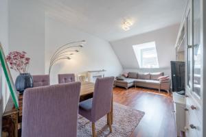 ein Esszimmer mit einem Tisch und einem Sofa in der Unterkunft Private Apartment in Hannover