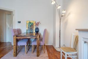 ein Esszimmer mit einem Holztisch und lila Stühlen in der Unterkunft Private Apartment in Hannover