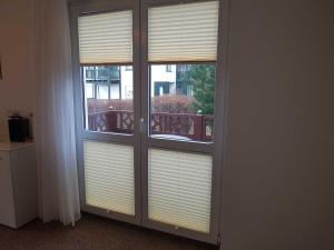 two windows with blinds on them in a room at Fewo Ostseeperle 04_KADO in Ostseebad Karlshagen