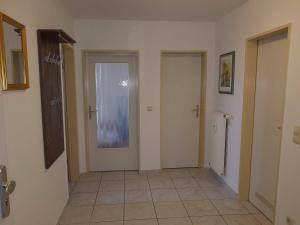 a hallway with two doors and a tile floor at Fewo Ostseeperle 04_KADO in Ostseebad Karlshagen