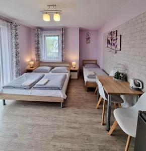 ザコパネにあるPokoje Gościnne Nowa Grańのベッドルーム1室(ベッド2台、テーブル、椅子付)