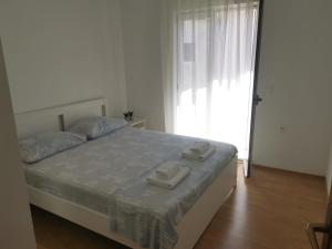 a bedroom with a bed with two towels on it at Apartman Katarina Promajna in Promajna
