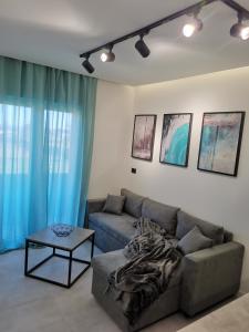 ein Wohnzimmer mit einem Sofa und einem Tisch in der Unterkunft Moderni apartman Tina in Mundanije