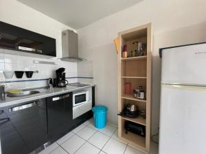 a kitchen with a sink and a refrigerator at Le Tournesol in Mimizan