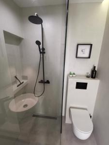 a bathroom with a shower and a toilet and a sink at Moderni apartman Tina in Mundanije