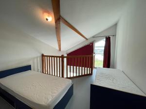 two beds in a room with a balcony at Le Tournesol in Mimizan