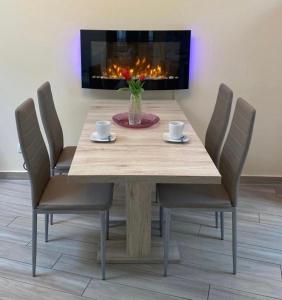 mesa de comedor con sillas y chimenea en 2Raum-Apartment Leznew en Leipzig