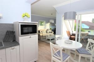 uma cozinha e sala de estar com uma televisão e uma mesa em KranichSuite - Zingst em Zingst