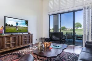 a living room with a tv and a couch and a table at Oak Tree Manor Permit# 259,056 in La Quinta