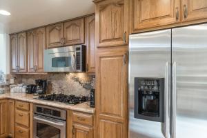 a kitchen with wooden cabinets and stainless steel appliances at Oak Tree Manor Permit# 259,056 in La Quinta