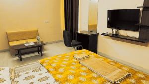 a room with a bed and a tv and a table at Mi Casa Sector 47 in Gurgaon