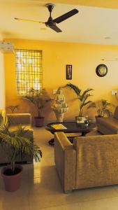 uma sala de estar com plantas e uma ventoinha de tecto em Mi Casa Sector 47 em Gurgaon