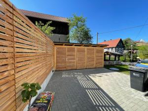 einen Holzzaun in einem Hinterhof mit einer Bank in der Unterkunft Neues Ferienhaus in Kurort Gohrisch