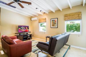 a living room with two chairs and a flat screen tv at Movie Colony Bungalow Permit# 3364 in Palm Springs