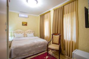 um quarto de hotel com uma cama e uma cadeira em HOTEL VLADi em Kutaisi